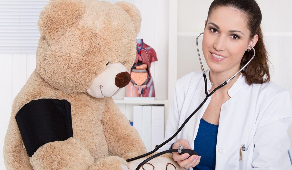 Young doctor is measure blood pressure on a teddy bear.